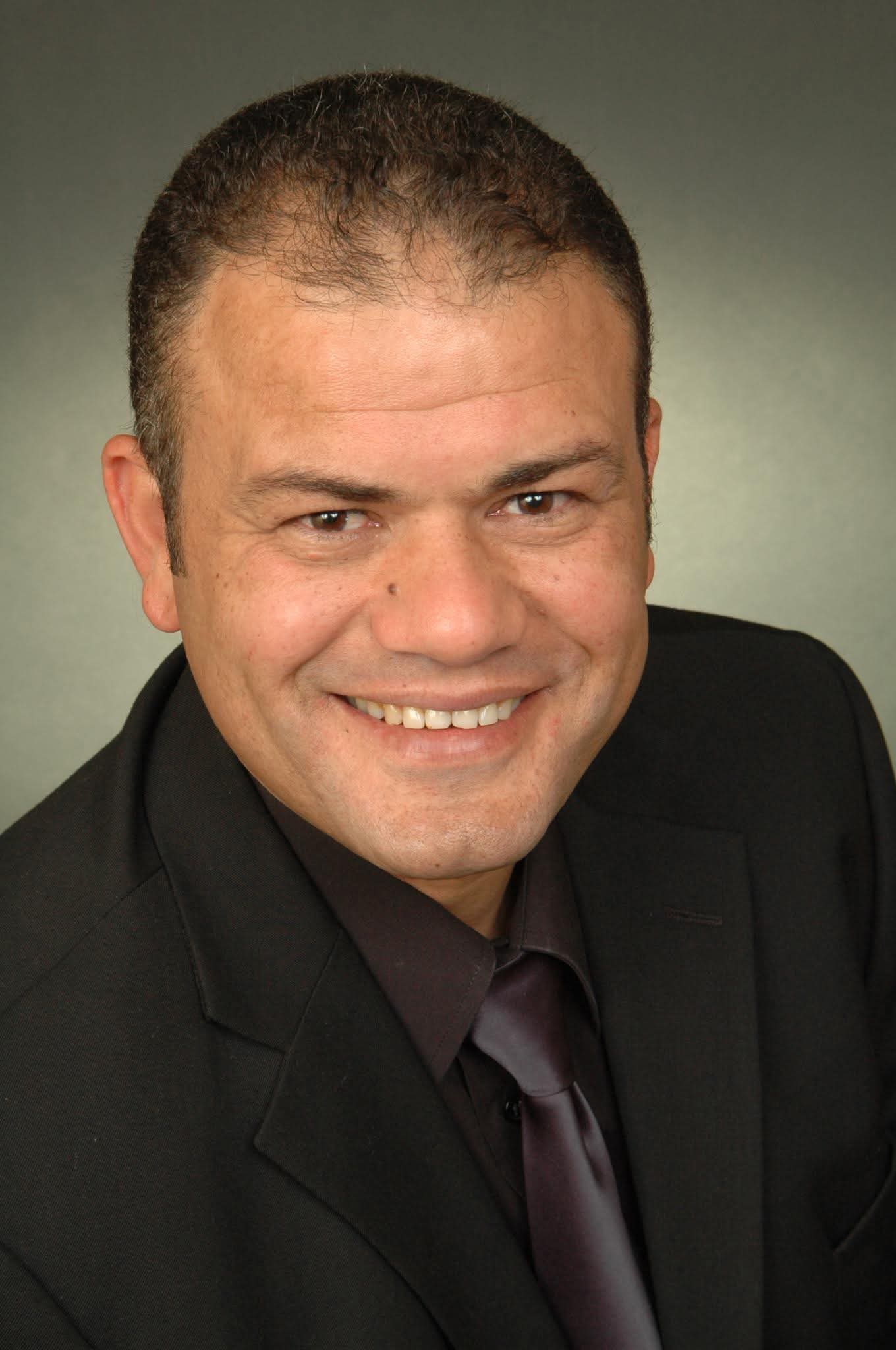 Professional headshot of Hatim Elafifi in a dark suit